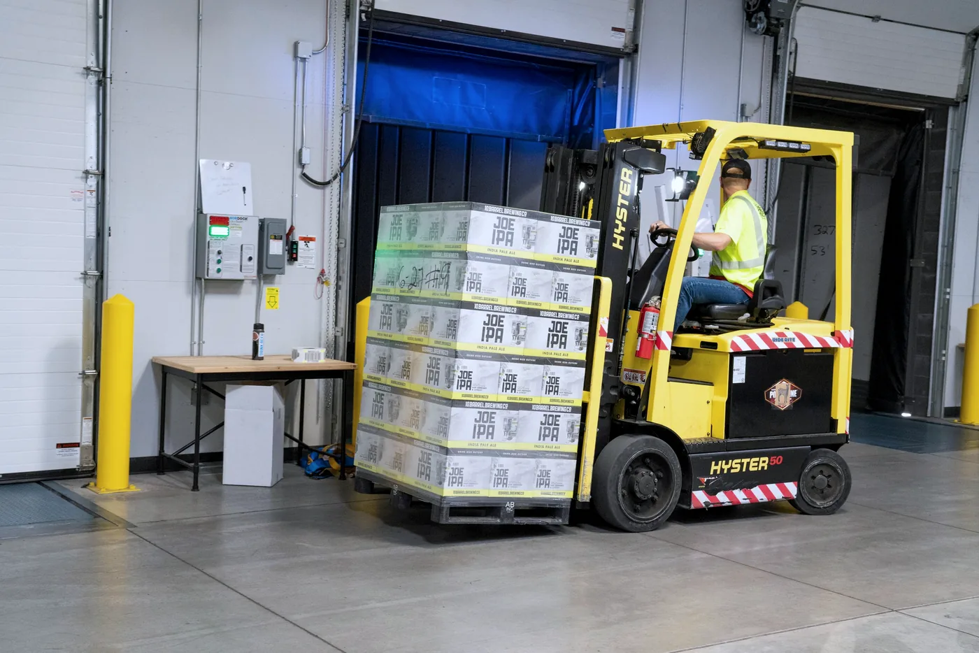 A forklift moving pallets through a racked EU distribution warehouse